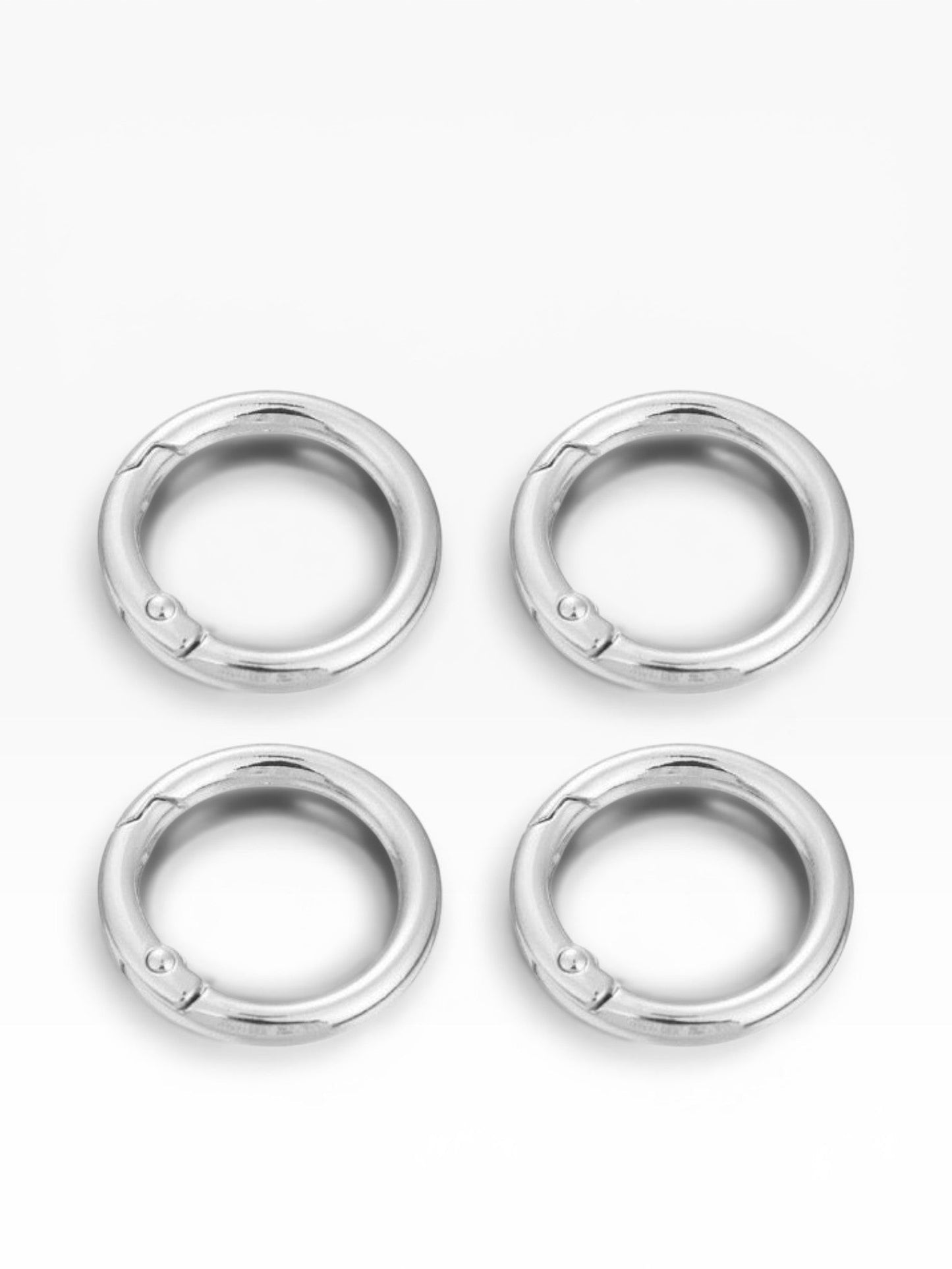 Quattro moschettoni rotondi a scatto color argento di Merceria & Tendenze, ideali per borse e accessori fai-da-te.